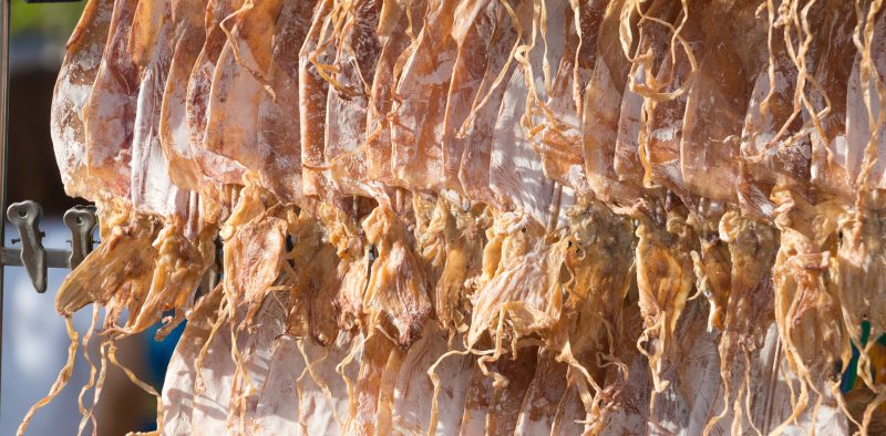 Dried squid hang in line for customer choose to grill at Thailand street market.